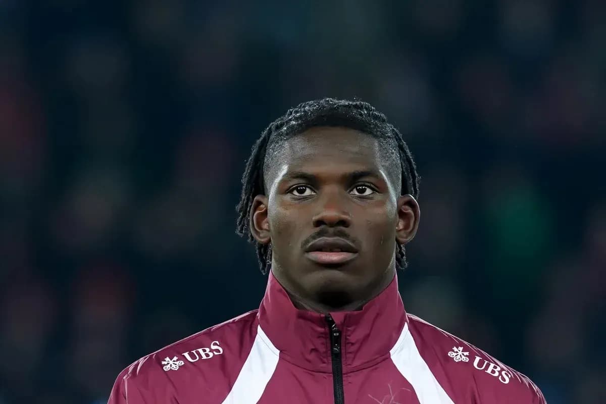 Player wearing a maroon jacket during match warm-up