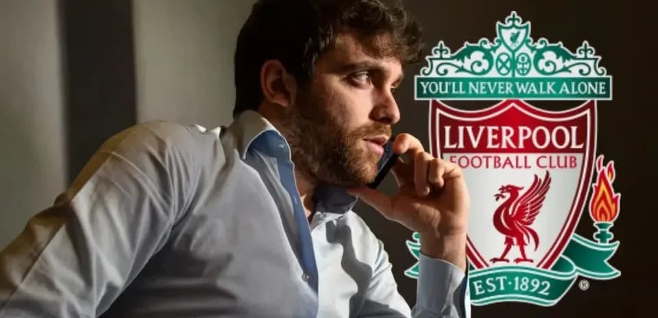 Man on phone with Liverpool FC logo in background