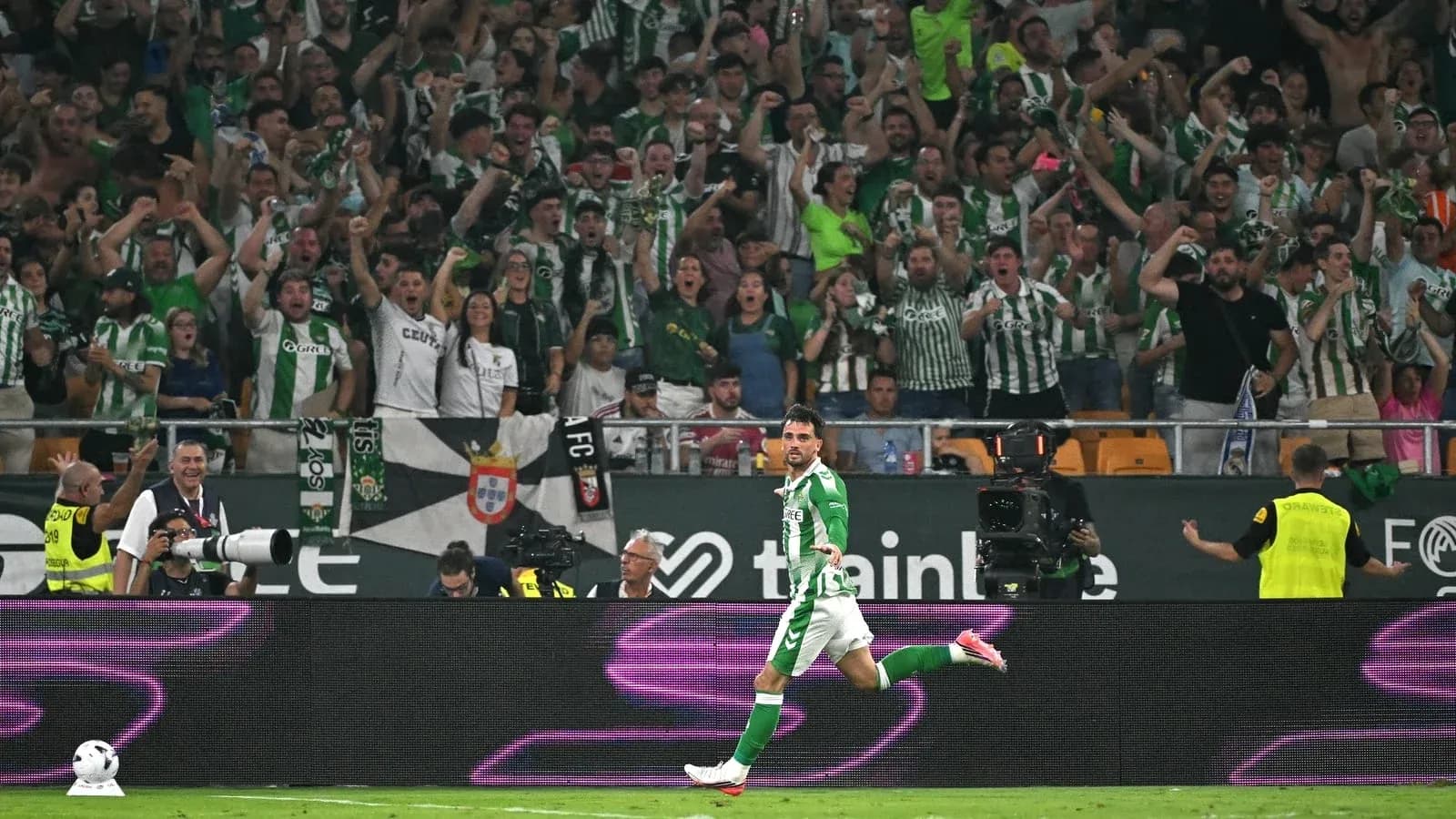 Player celebrating goal with cheering fans in stadium