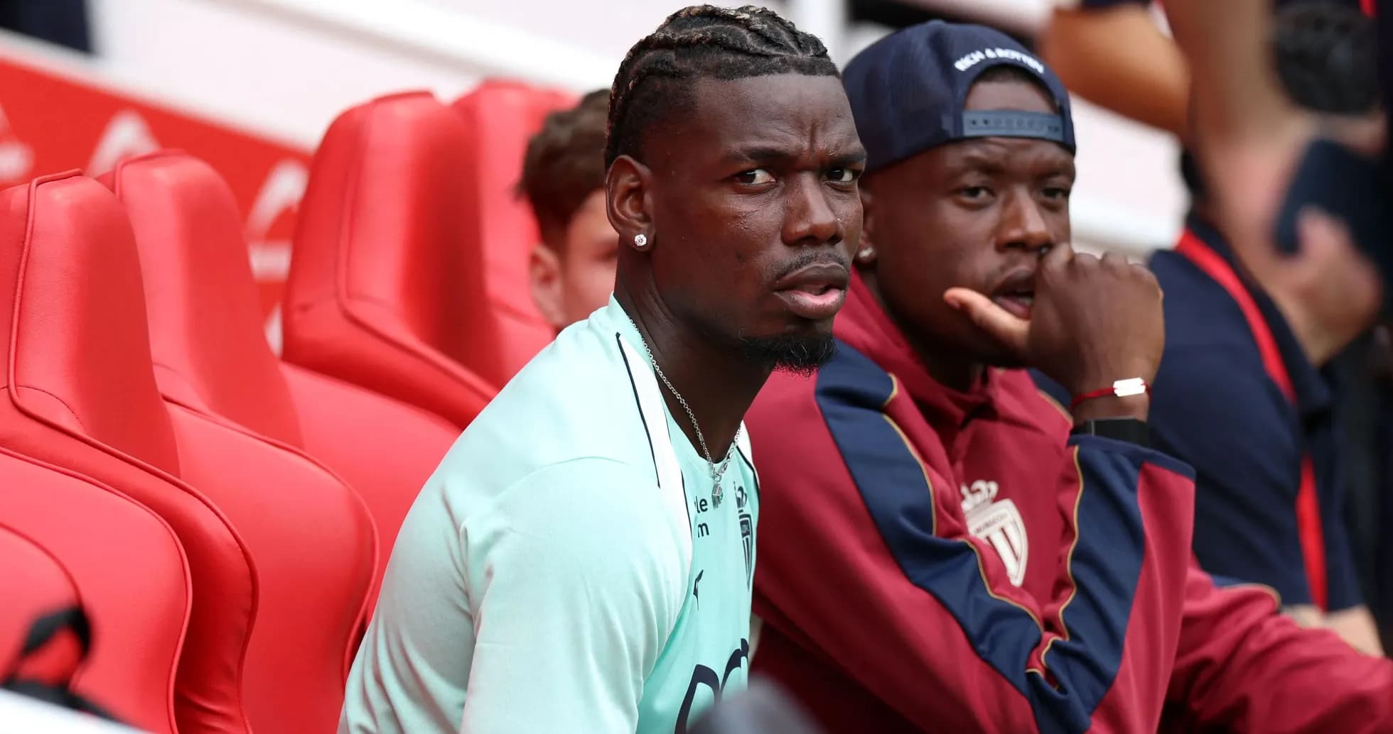 Two players sitting on red benches during match
