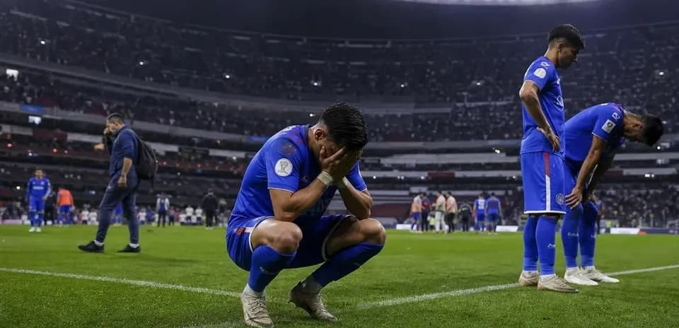 Player kneeling on field with head in hands