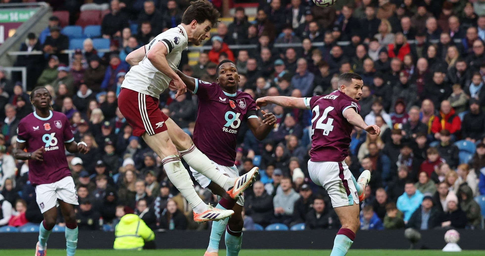 Arsenal player heading ball against Burnley defenders