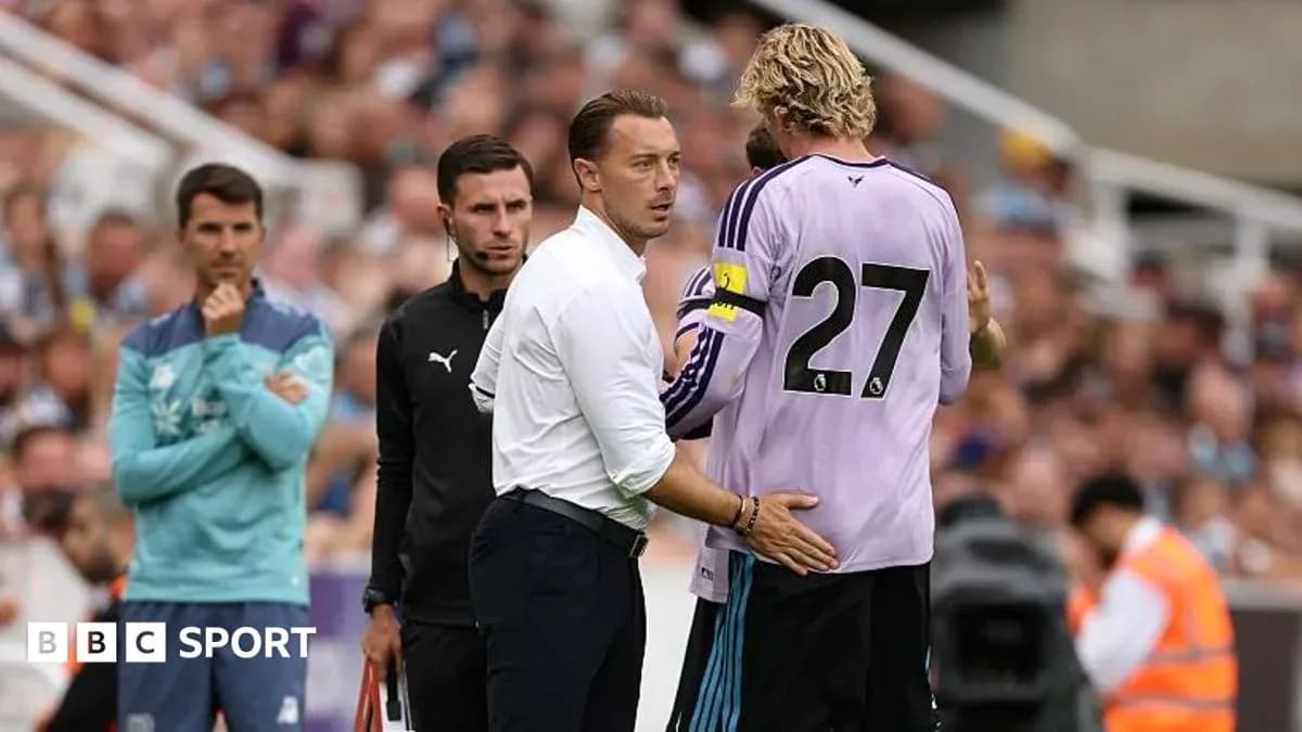 Coach speaking to goalkeeper during match substitution
