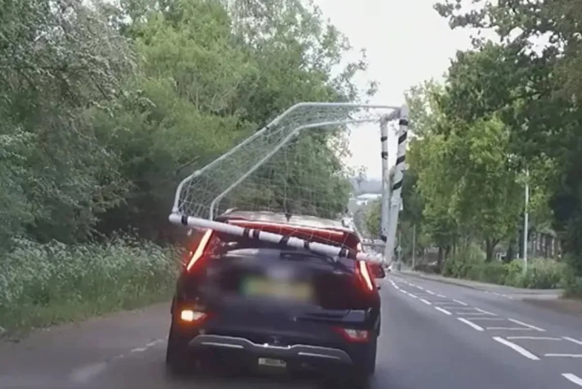 Car transporting a football goal on the road
