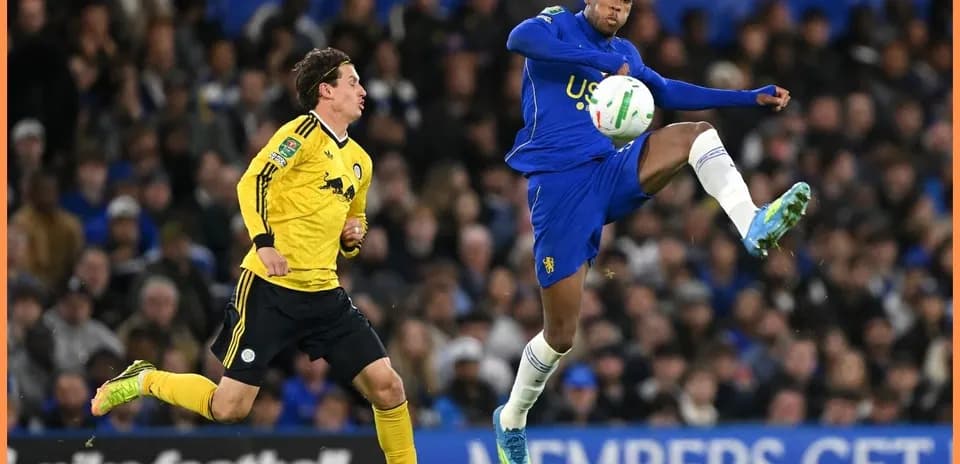 Player kicking the ball during football match action