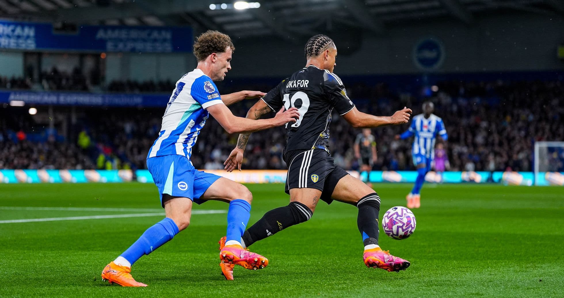 Leeds player tackling Brighton opponent in match