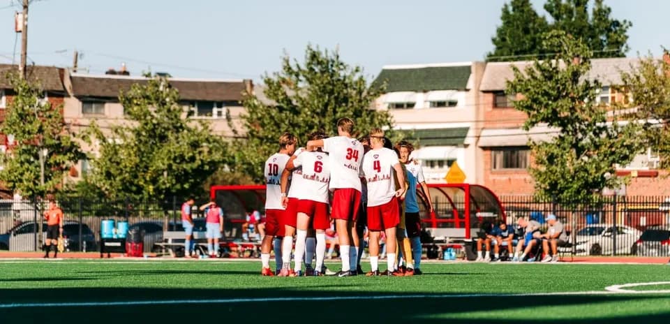 Team huddled together on soccer field before match