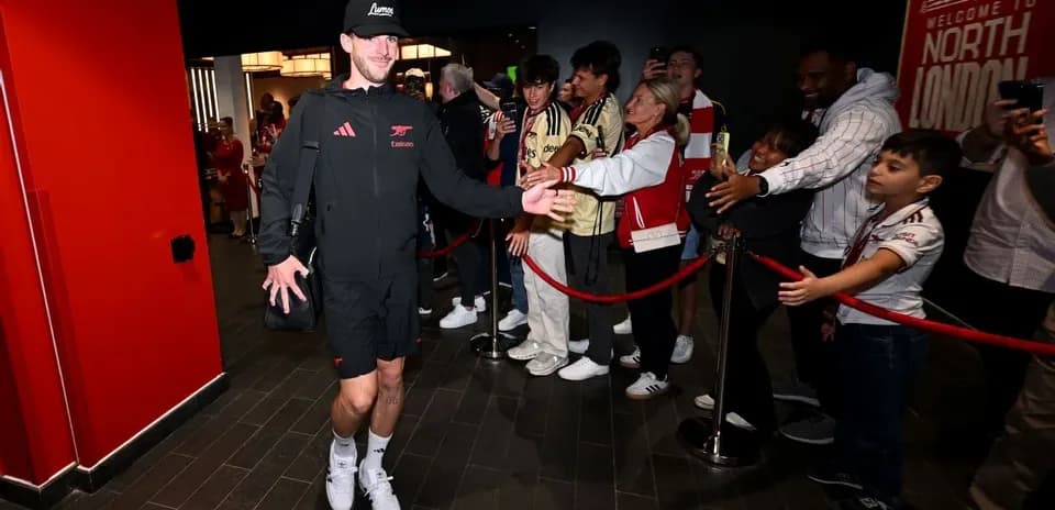 Player greeting fans while entering stadium lobby