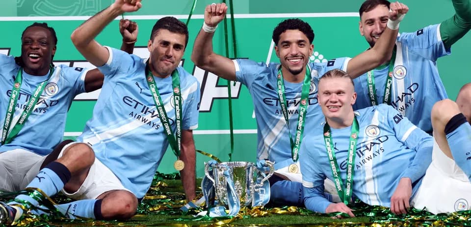 Manchester City players celebrating with trophy