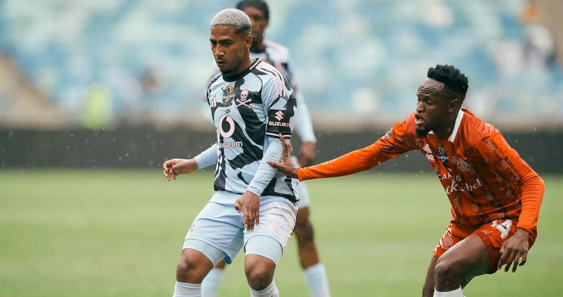 Player in striped jersey evading opponent in orange