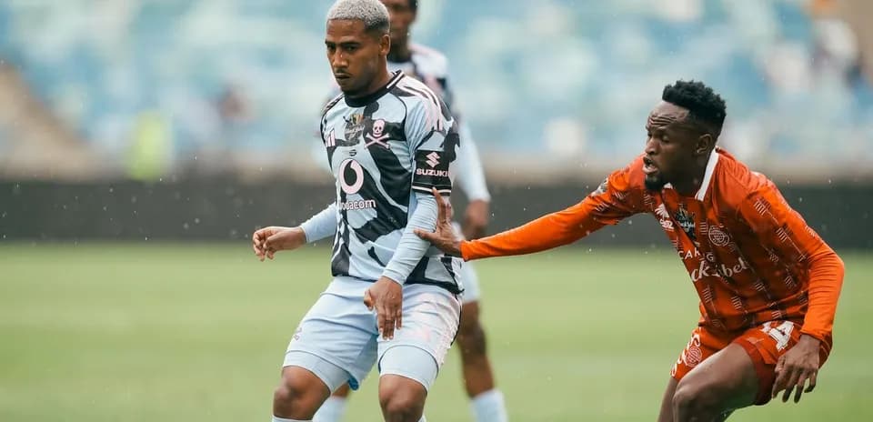 Player in striped jersey evading opponent in orange