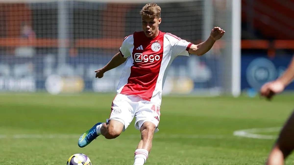 Player in Ajax kit kicking the ball during match