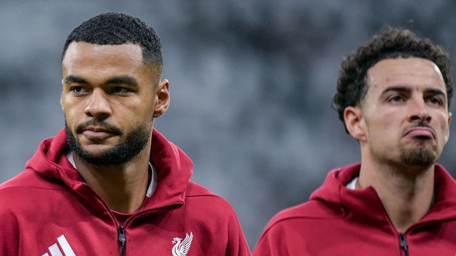 Two Liverpool players in training jackets during warm-up
