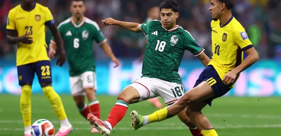 Mexico player tackling Ecuador player during match