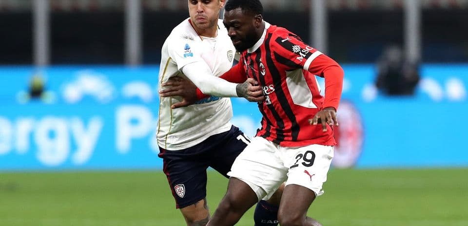 AC Milan player challenging Cagliari opponent for the ball
