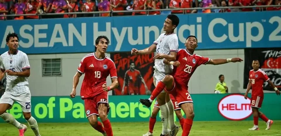 Players contesting a high ball during ASEAN Cup match