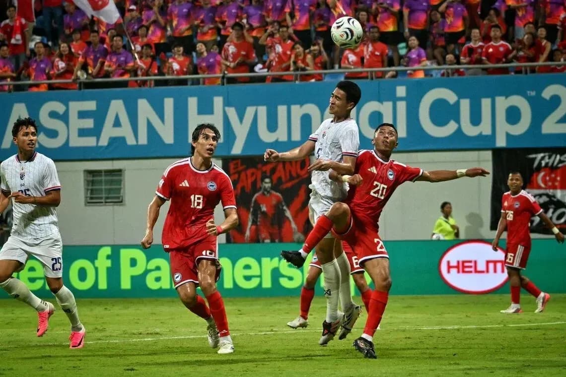 Players contesting a high ball during ASEAN Cup match