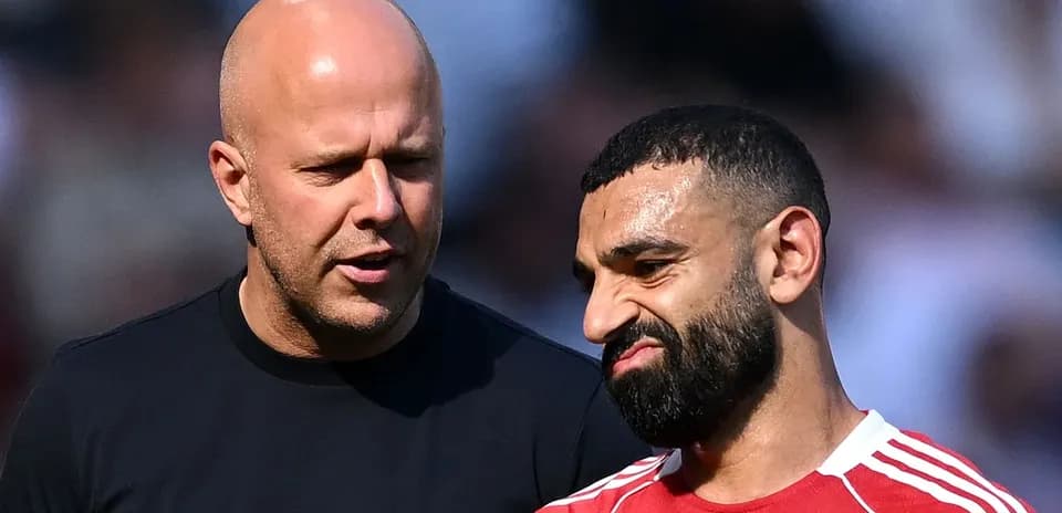 Two men conversing on a football pitch