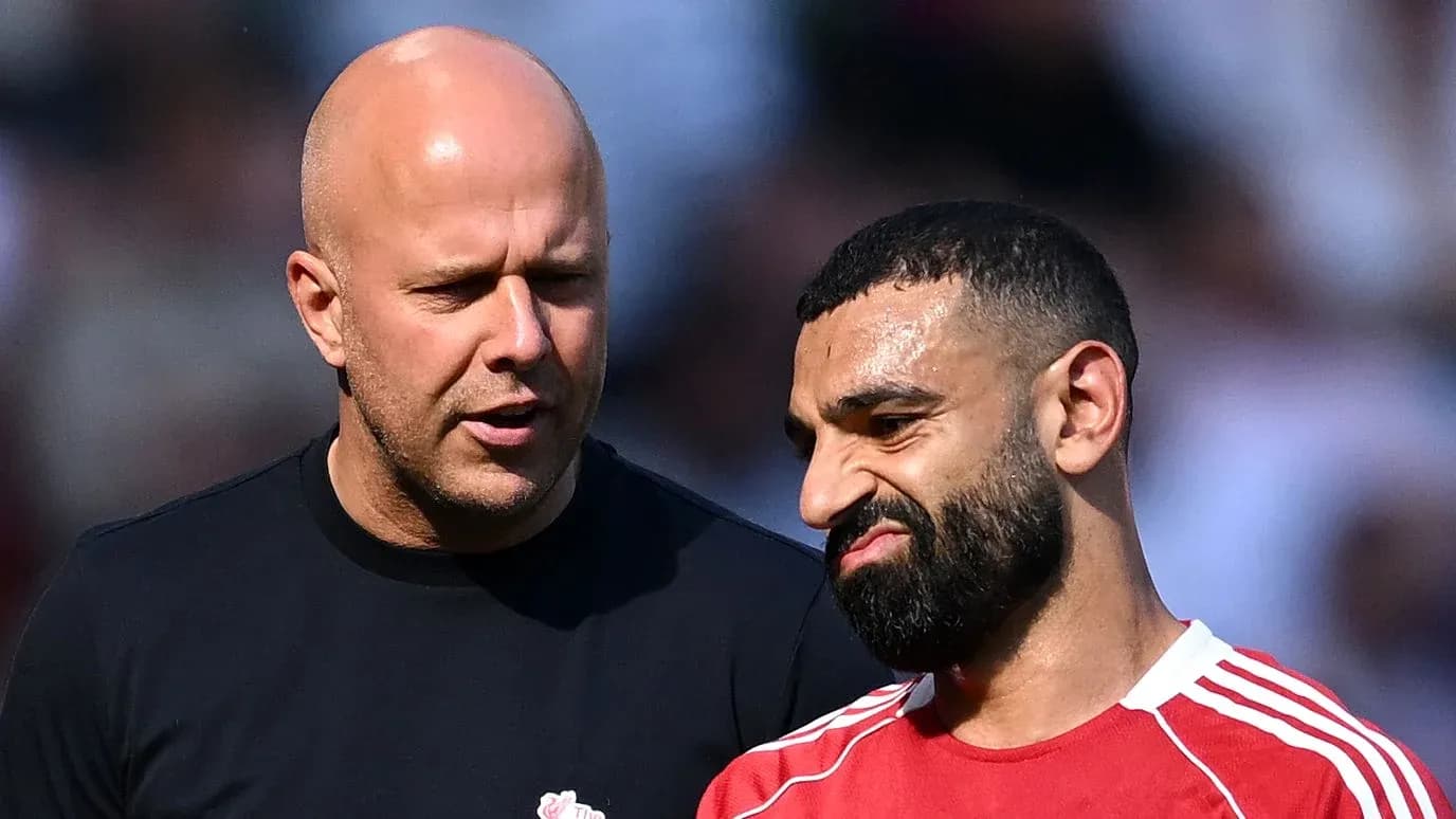 Two men conversing on a football pitch