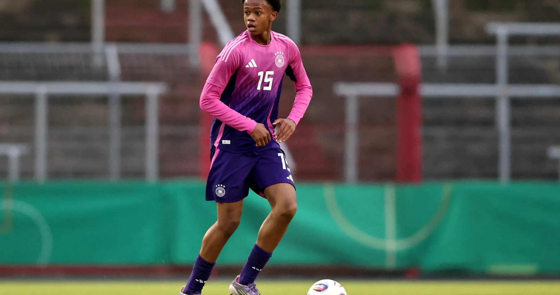 Player in training kit dribbling a soccer ball