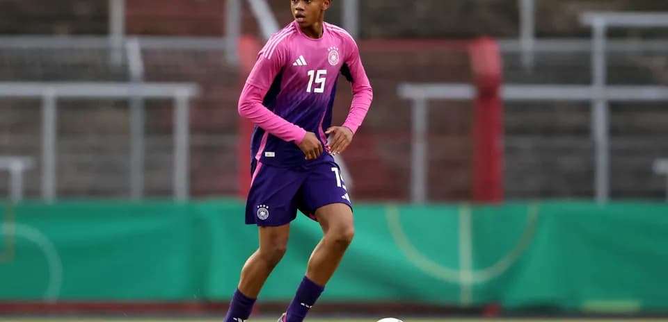 Player in training kit dribbling a soccer ball