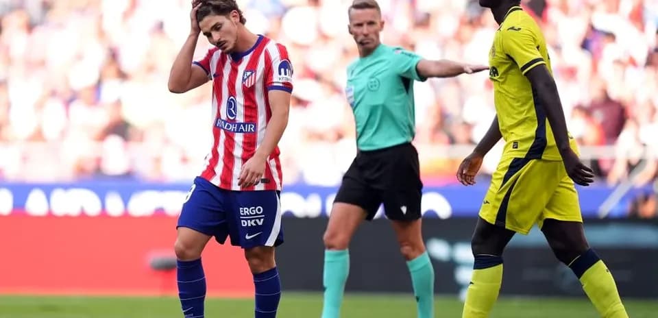 Atletico Madrid player reacting during match with referee