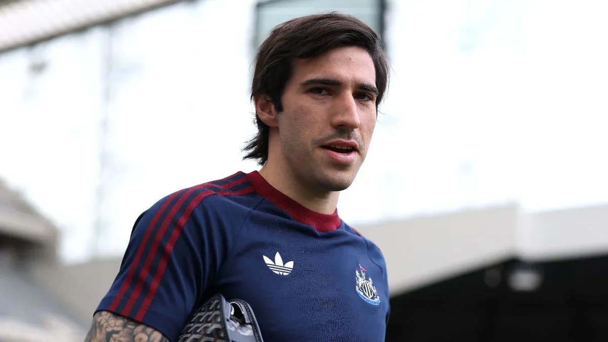 Player wearing Newcastle kit at stadium entrance
