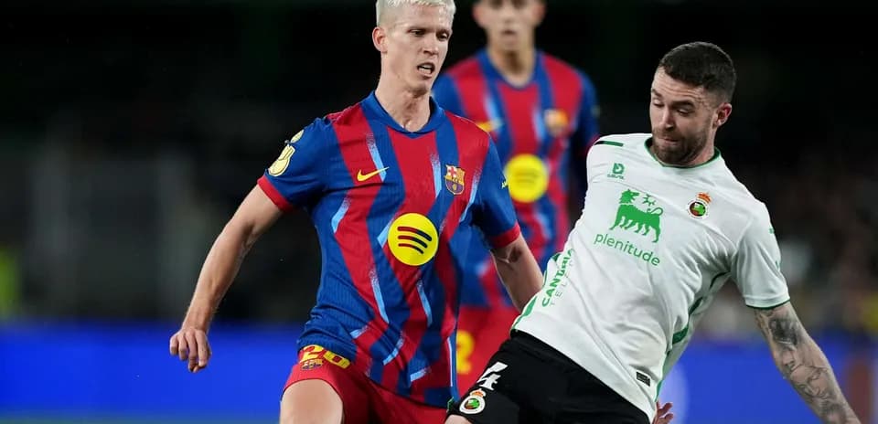 Barcelona player tackling Racing Santander opponent