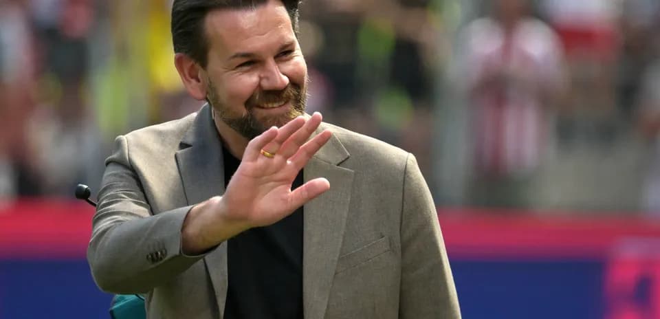 Man waving during a sports event on field