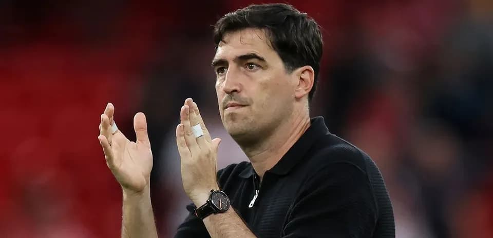 Coach applauding in front of a cheering crowd