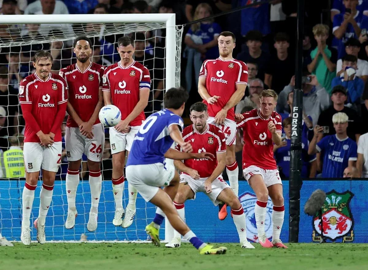 Player taking a free kick against defensive wall
