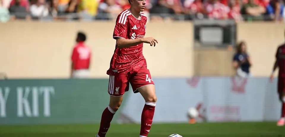 Player in red Liverpool kit running with ball