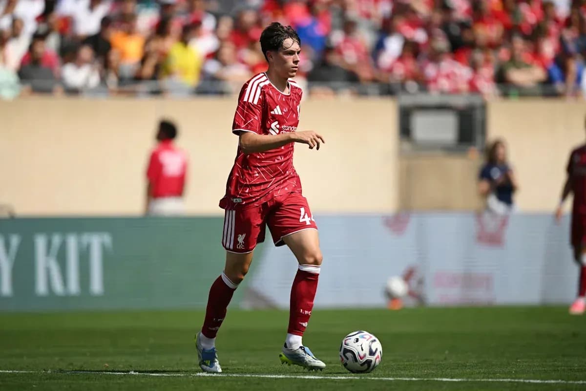 Player in red Liverpool kit running with ball