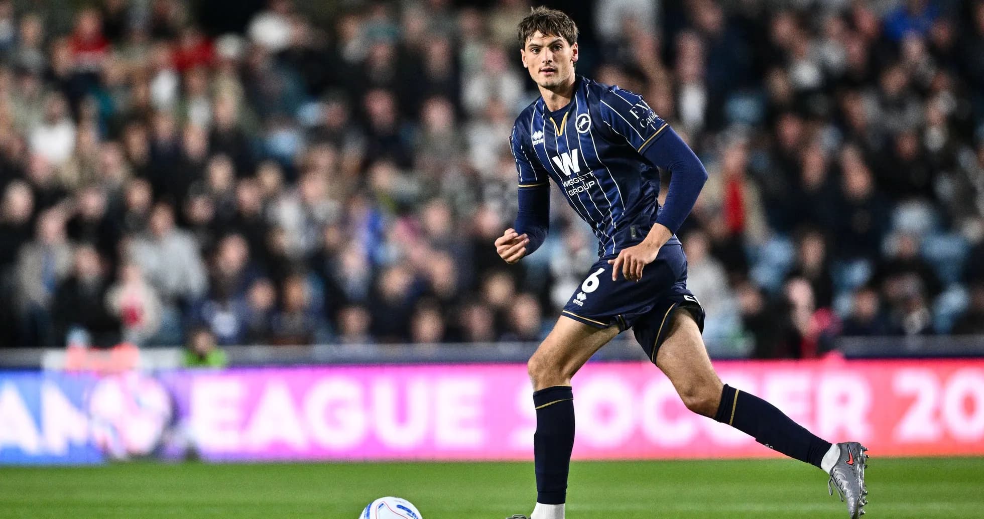 Player in blue kit running on the field