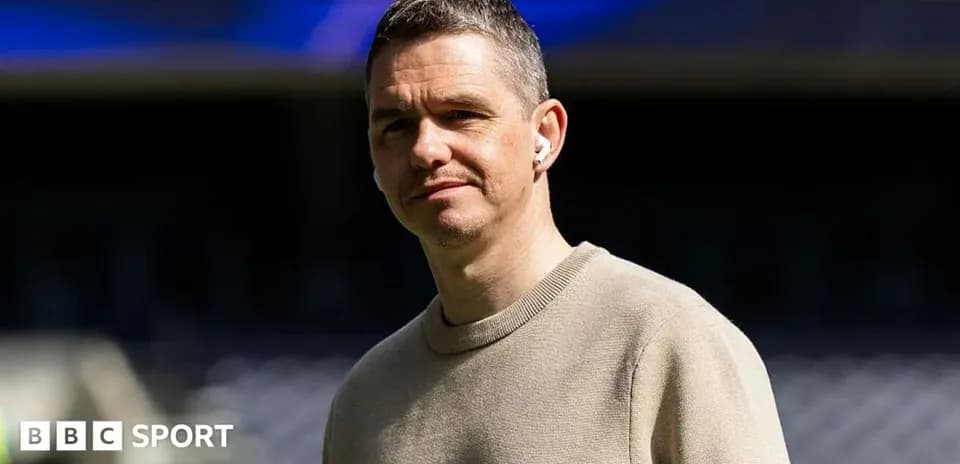 Man wearing earbuds standing in stadium