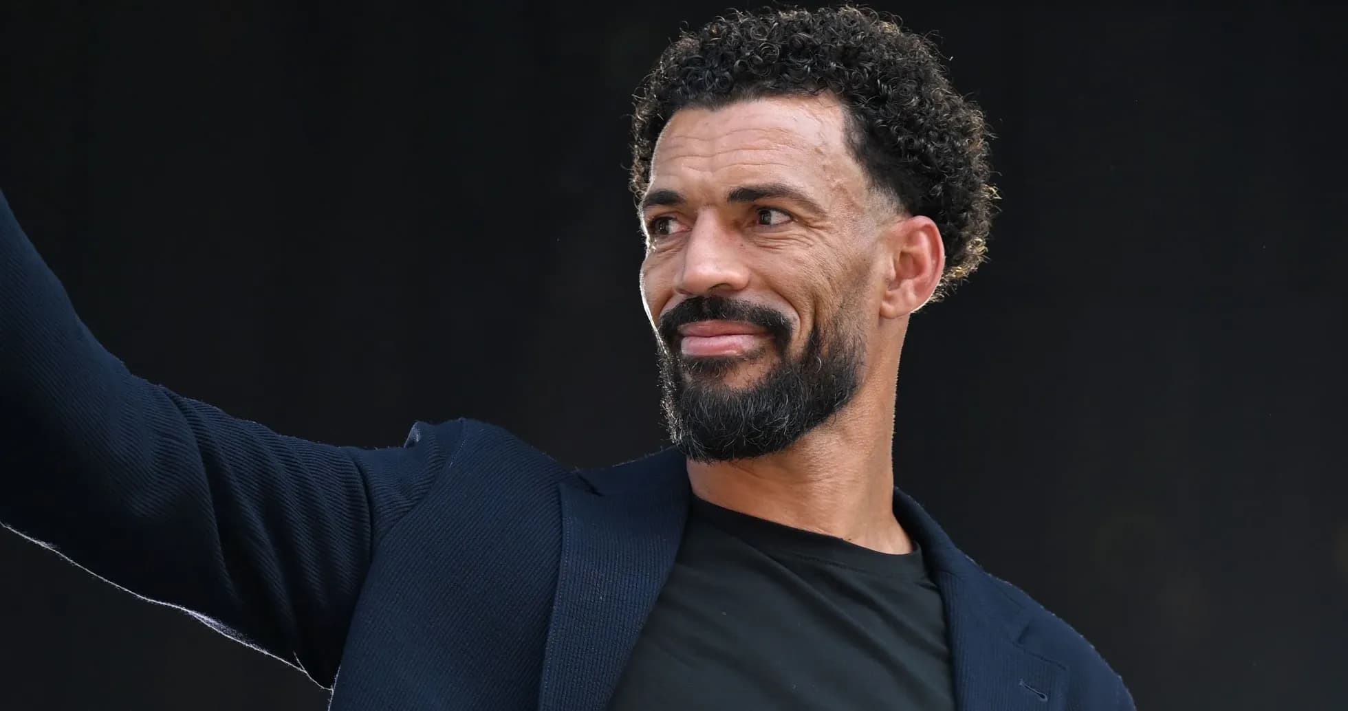 Man in suit waving at an event