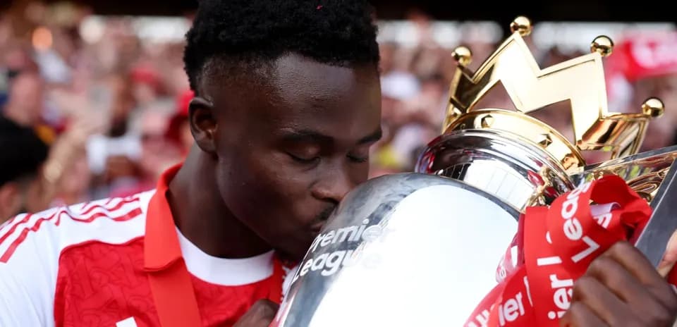 Player kissing Premier League trophy in celebration