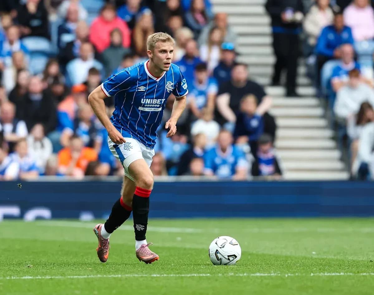 Player in blue jersey running towards soccer ball