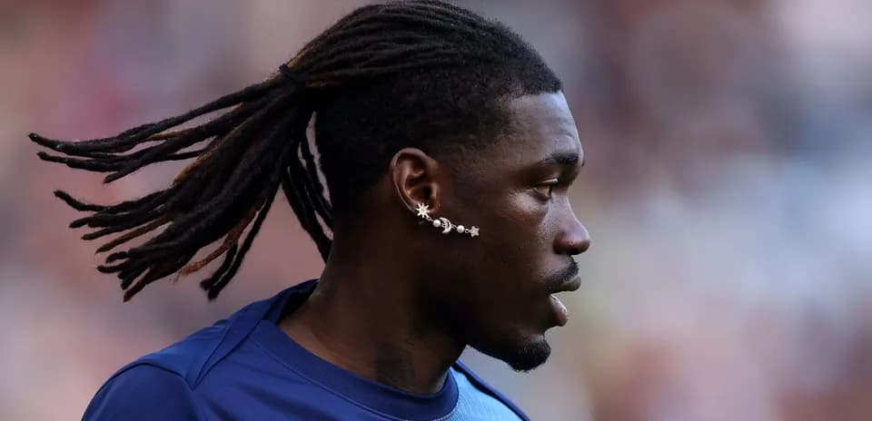 Player with dreadlocks and unique earrings in profile