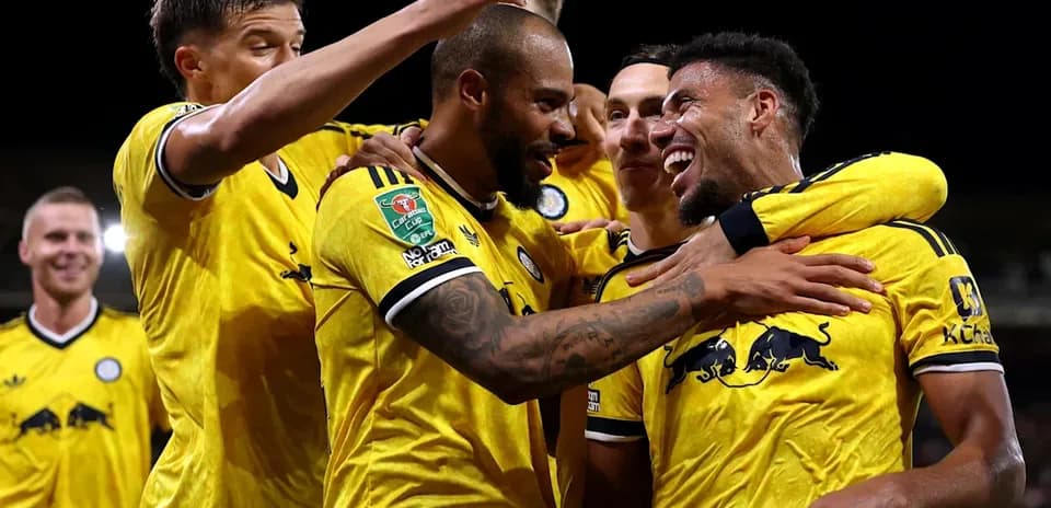 Players celebrating a goal in yellow jerseys