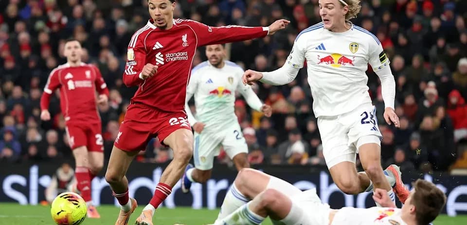Liverpool player evading Leeds United tackle on pitch