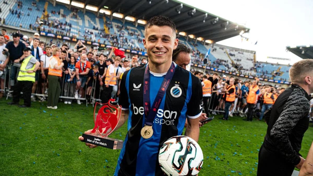 Player holding trophy and ball on pitch celebration