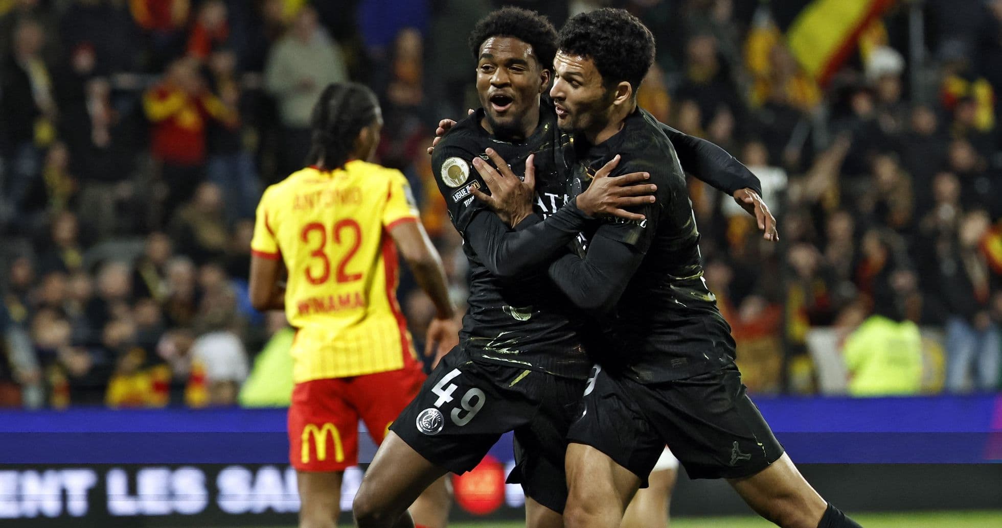 Two PSG players celebrating a goal on field