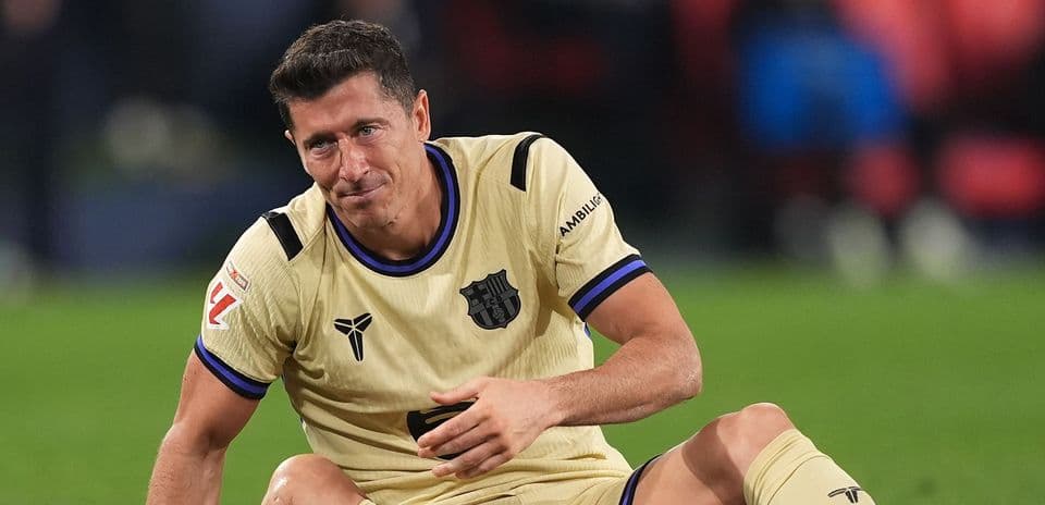 Player sitting on field wearing FC Barcelona kit