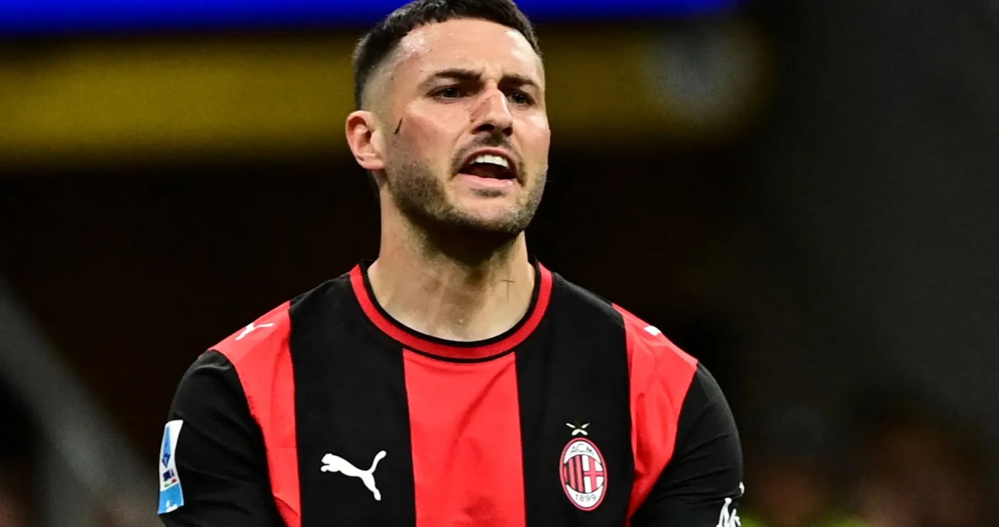 Player in AC Milan jersey reacting on the field