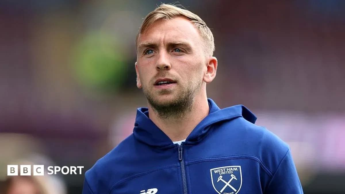 Player wearing West Ham United hoodie on pitch