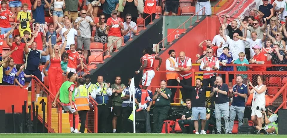 Player celebrating a goal with excited fans