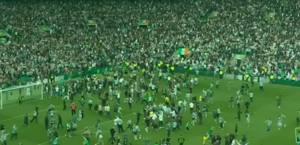 Fans celebrating on the pitch after the match