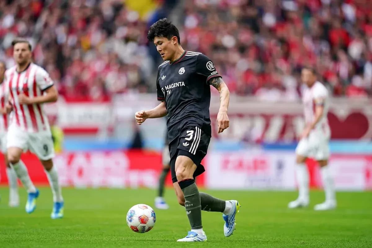 Player in black uniform dribbling ball during match