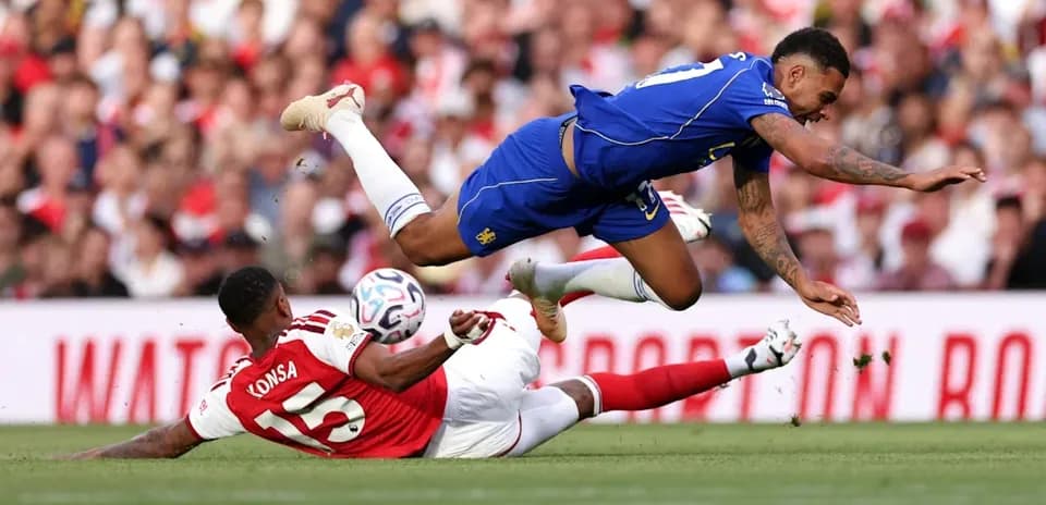 Player falling over another during football match
